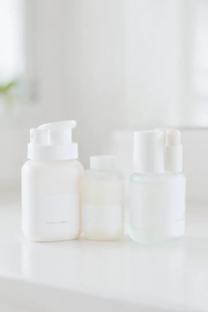 gentle skincare routine setup with unlabeled bottles on a minimal