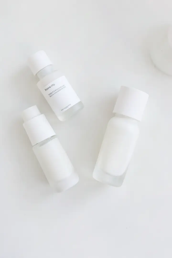 gentle skincare routine setup with unlabeled bottles on a minimal