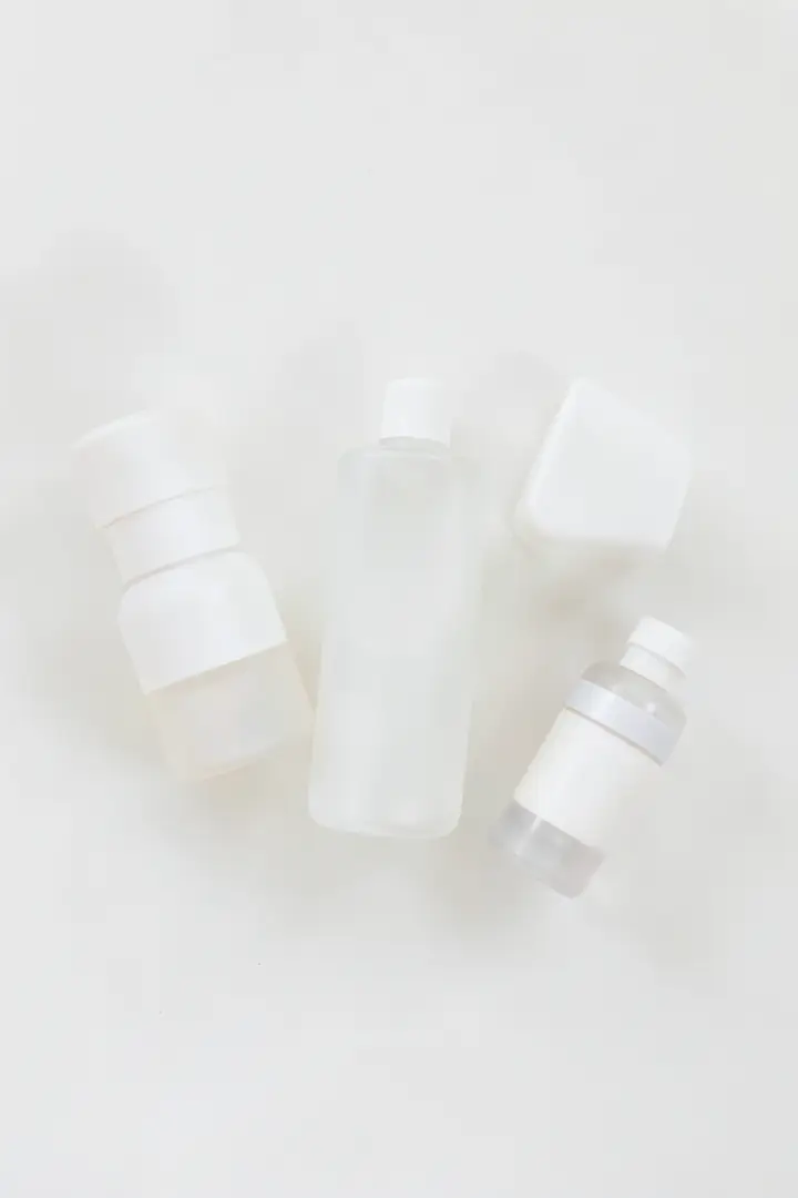gentle skincare routine setup with unlabeled bottles on a minimal