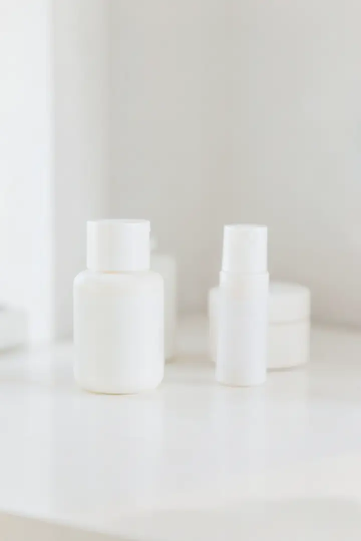 gentle skincare routine setup with unlabeled bottles on a minimal